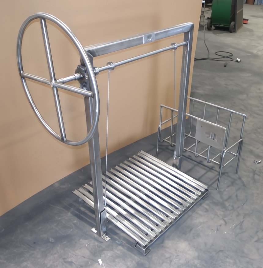 Argentine Architectural Grill Model 241115 with side brasero and adjustable-height V-grate, stainless-steel frame with a wheel lift system for masonry firebox installation.