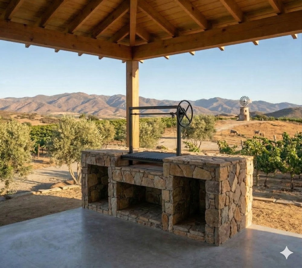 Argentine bolt-in grill kit with adjustable wheel height control installed in a stone masonry firebox under a covered outdoor patio overlooking a ranch landscape.
