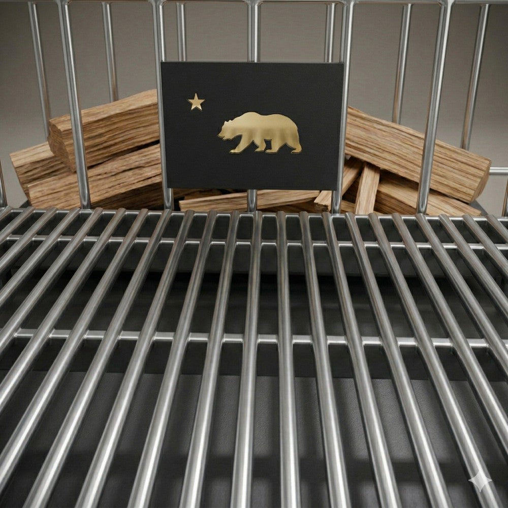 Close-up of the Argentine V-grate and Bear logo panel, showing wood stacked behind the grate for charcoal or wood-fired grilling.