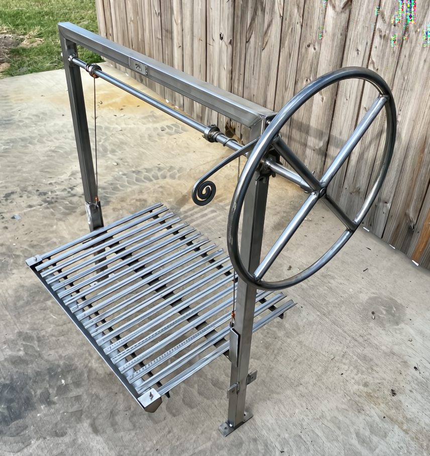 Argentine architectural grill kit with adjustable wheel and stainless round rod grate for bolt-in installation in a masonry firebox
