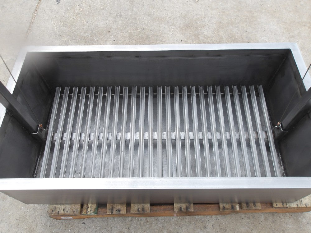 Interior view of stainless Santa Maria built-in grill with adjustable round rod grilling grate and heavy-duty firebox for wood or charcoal cooking.