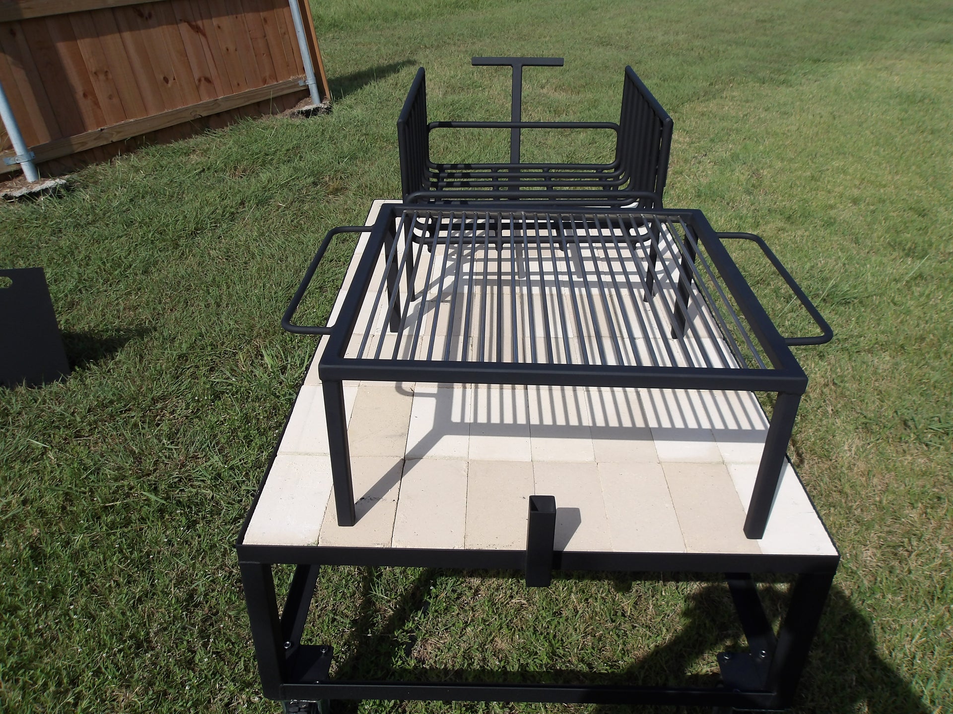 Exhibition Fire Table with All Terrain Casters, Small Asado Grill, Heavy Duty Large Brasero, and a Three-Sided Hinged Wind Block