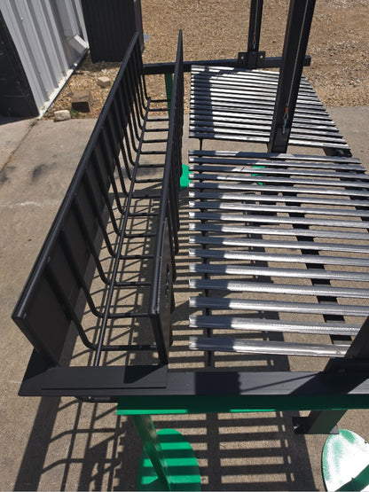 Close-up of split Argentine grill kit showing rear brasero ember basket and stainless V-grate cooking surface with flat steel flange for masonry firebox installation