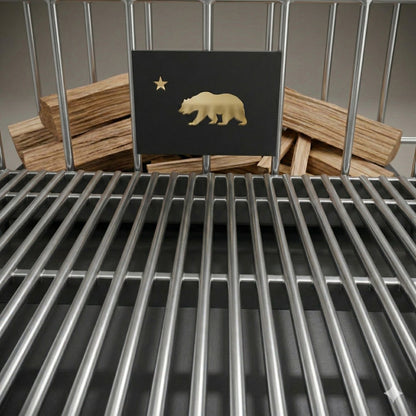 Close-up of the Argentine V-grate and Bear logo panel, showing wood stacked behind the grate for charcoal or wood-fired grilling.