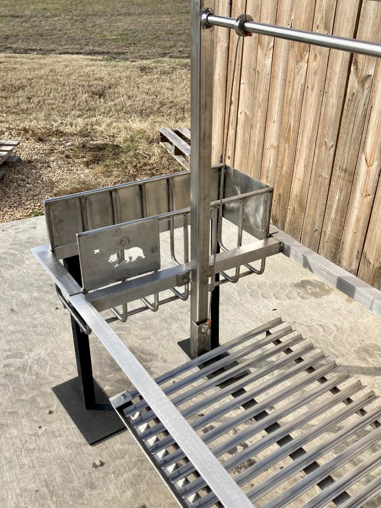 Close-up of the stainless brasero and grate system on an Argentine grill kit, highlighting the 4-sided flange and adjustable cooking surface.