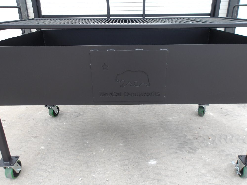 Firebox detail of Portico BBQ Grill #4947 featuring embossed NorCal Ovenworks bear logo on steel panel.