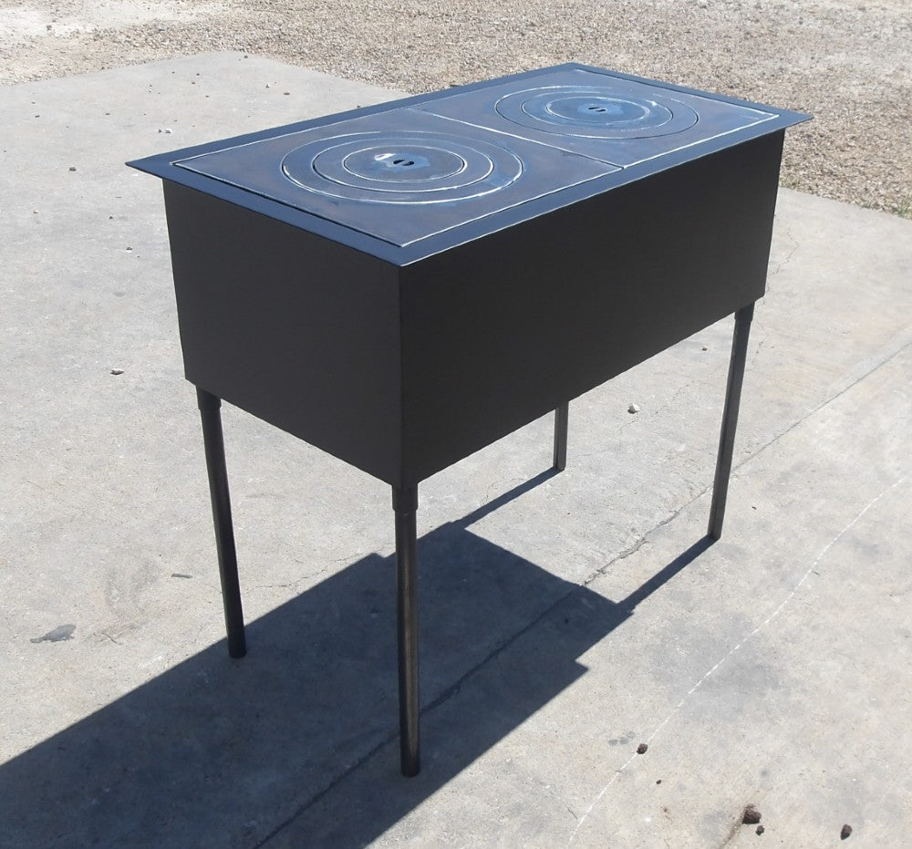 Angled view of retro wood stove grill with dual fire plates, black steel construction and elevated outdoor cooking design